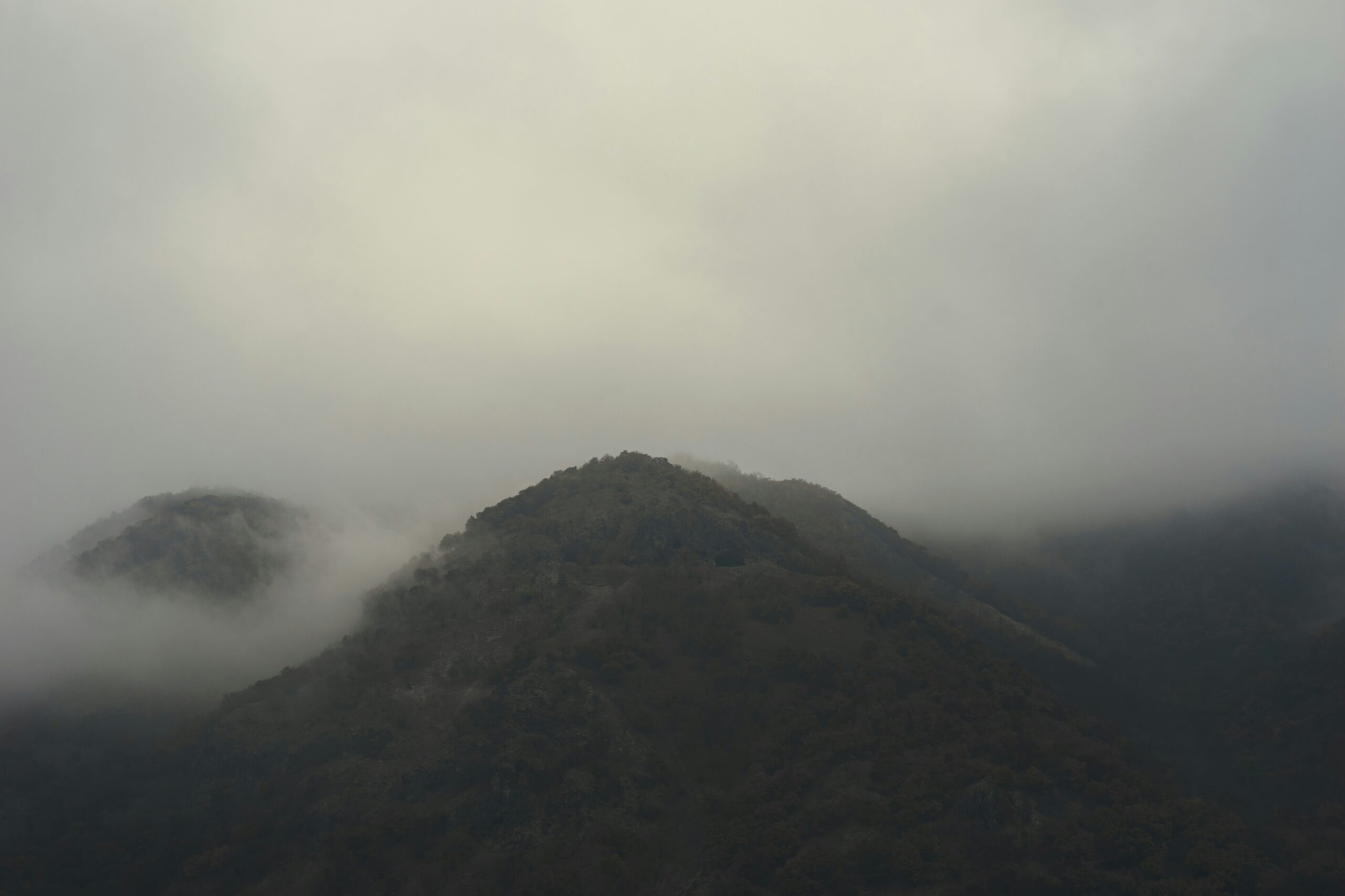 An eery image of a mountain in the mist.