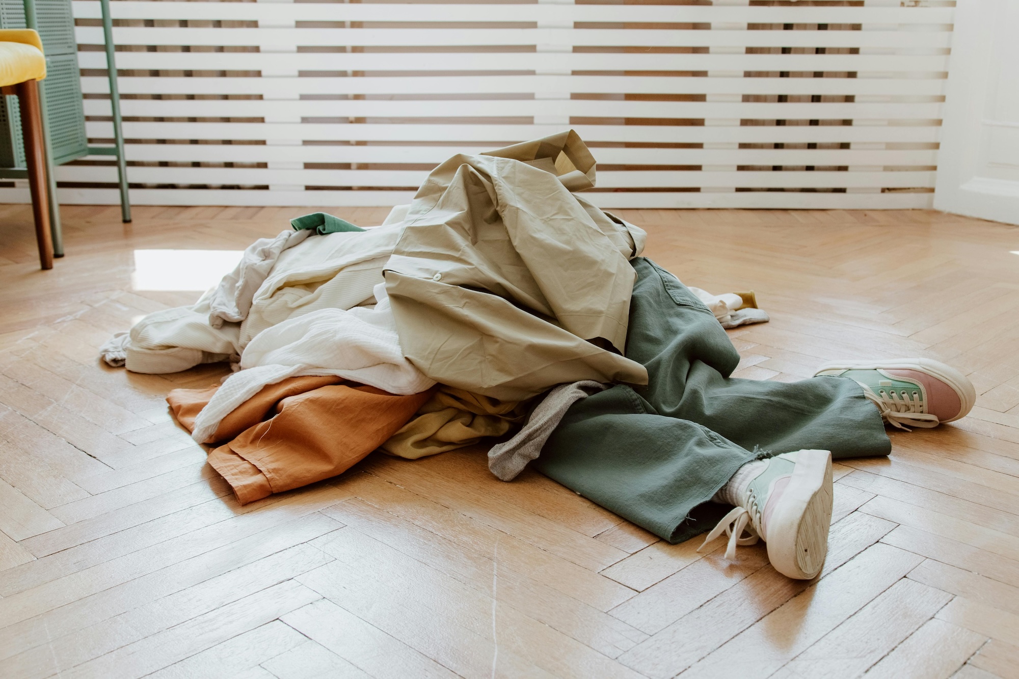 A person lies buried underneath a pile of clothes