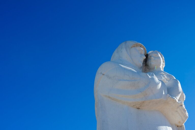An statue of a mother holding a child.