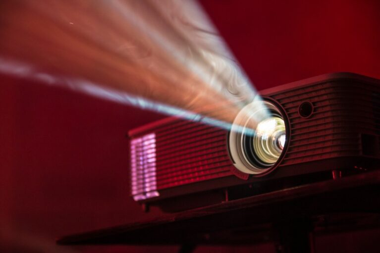 A projector in front of a red background